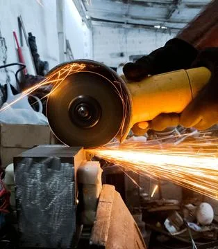 Angle grinder with sparks in the workshop Stock Photos