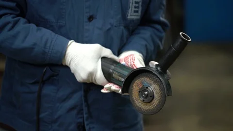 The angle grinder turns on and spins on hands with white gloves. Stock Footage 122245443