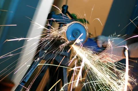 Angle grinder in use, cutting pipes for waterwork. Stock Photos