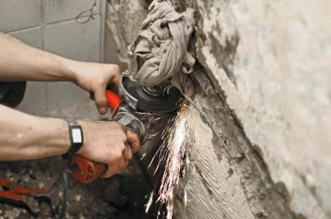 Angle grinder in use, cutting pipes for waterwork. Stock Photos