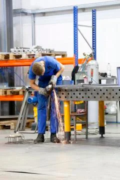 An angle grinder worker cuts metal Stock Photos