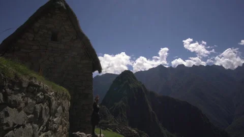 An angle of Macchu Picchu in the backdrop beside the woman traveler is a Stock Footage 264459174