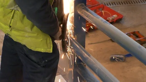 Angle metal grinder tool cutting and sawing steel tubes with sparks Stock Footage 94599095