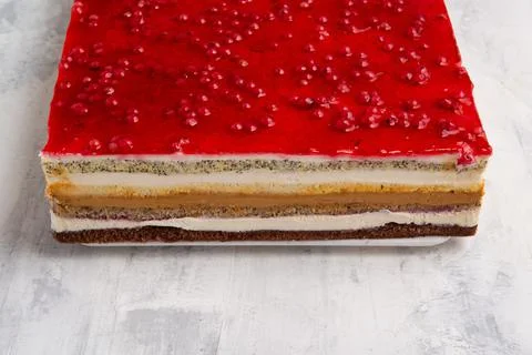 Angle shot of a multi-layered cake with a red currant jelly layer on top. 스톡 사진