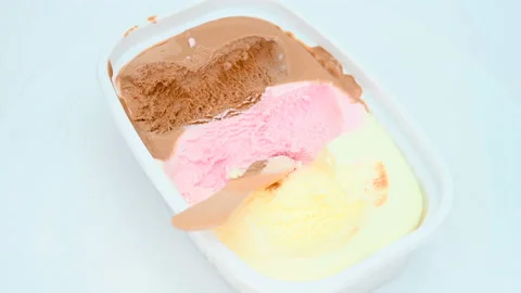 Angle view cup of multicolor ice cream with some eaten rotating Stock Footage 159547439