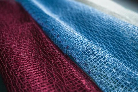 Angle view of netted fabrics in maroon light blue and white colors Stock Photos