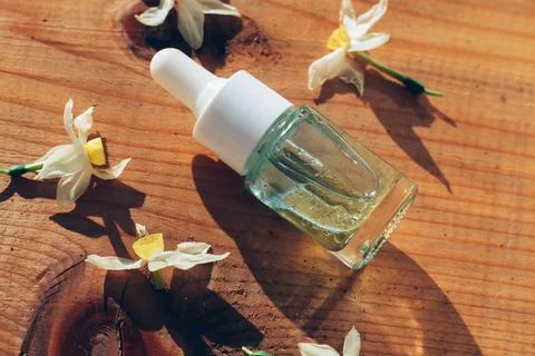 Angle view of a transparent bottle with dropper on the natural wooden background Stock Photos