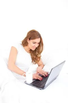 Angle view of woman using laptop computer in bed Stock Photos