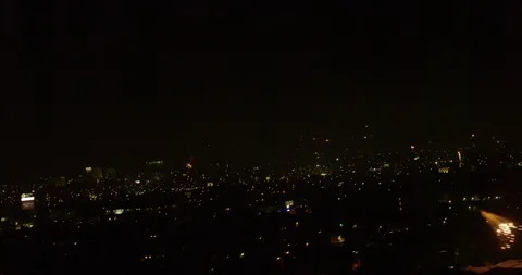 Angled aerial moving downward during firework show over city, night Stock Footage 102066677