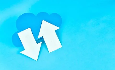 Angled blue cloud with white upload and download arrows on blue background Stock-Fotos