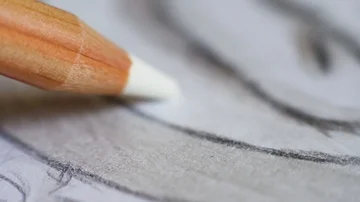 Angled close up (macro) of a graphite pencil drawing a line on textured paper. Stock Footage 85510529