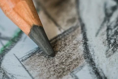 Angled close up (macro) of a graphite pencil drawing a line on textured white 스톡 사진