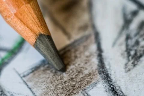 Angled close up (macro) of a graphite pencil drawing a line on textured white Foto stock
