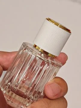 Angled Close Up View of Hand Holding Luxury Glass Perfume Bottle 스톡 사진