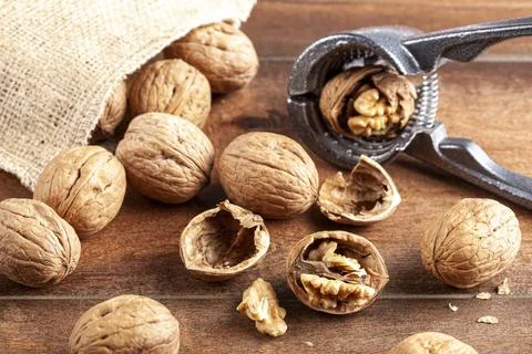 Angled selective focus image of walnuts in shell scattered out of a vintage b Stock Photos