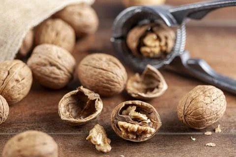 Angled selective focus image of walnuts in shell scattered out of a vintage b Stock Photos
