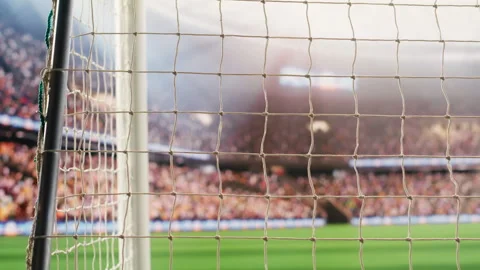 Angled soccer goal net and side post framing empty pitch with blurred stands Stock Footage 338000032