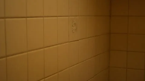 Angled View of Aged Bathroom Tile Corner with Warm Ambient Light Stock Footage 346137638