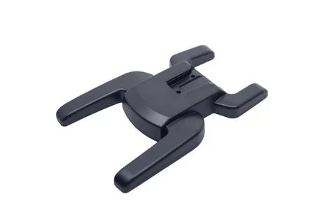 An angled view of a black plastic camera flash hot shoe adapter mount isola.. Stockfoto's
