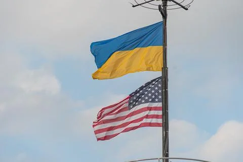Angled view of a flagpole with two flags blue, yellow and red, white, blue .. Foto stock