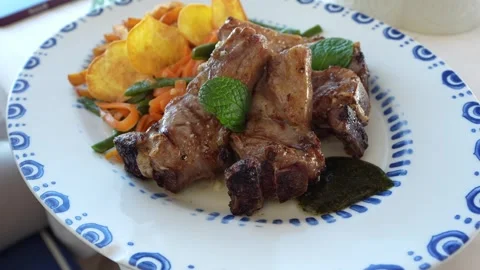 Angled view of lamb chops and vegetables on a plate Stock Footage 301367350