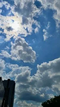 Angled view of a large, window covered building corner against a blue, clou.. Fotos de archivo