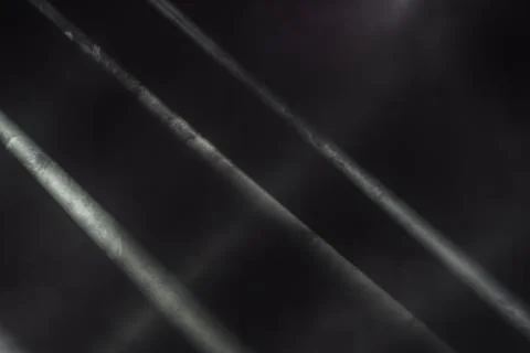 Angled view of a metallic bridge with parallel beams under stage lighting, sh Stock Photos