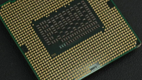 Angled View of Microprocessor with Gold Contact Pins on Dark Surface Stock Footage 337016443