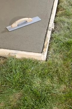 Angled view of a tool sitting on top of cement Stock Photos