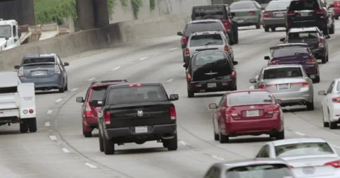 Angled view of traffic heading south on 110 freeway in Downtown LA 4K Stock Footage 63644977