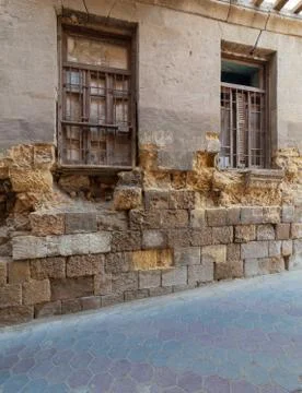 Angled view of two adjacent broken windows and grunge stone bricks wall Stock Photos