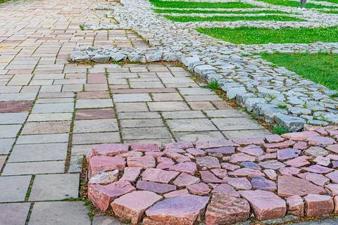 An angled view of a weathered cobblestone path in an old European city, trans Stock Photos