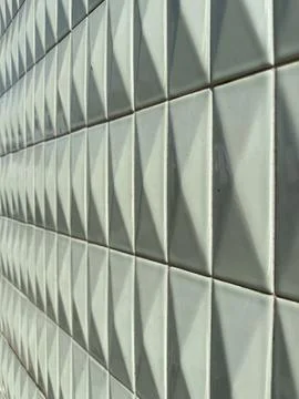 Angled view of white ceramic tiles with a raised diamond relief pattern cre.. Stock Photos