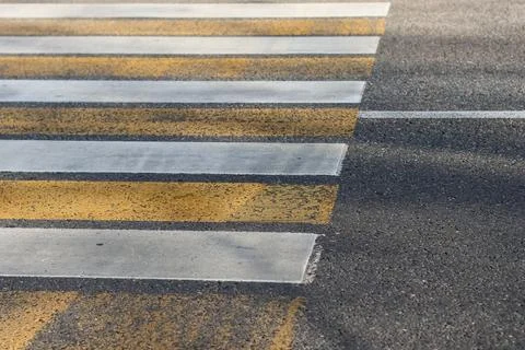 Angled view of worn zebra crossing stripes in yellow and white Foto stock