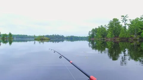 Angler casting rod with artificial baitfish lure for big mouth bass in the .. Stock Footage 282688782