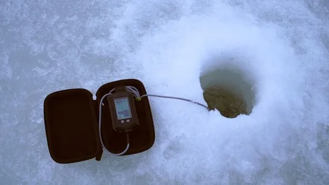 Angler catches fish with a winter echo sounder in the hole Stock Footage 105209450