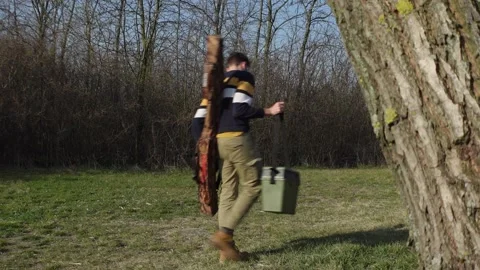 Angler disappearing behind a tree Stock Footage 210237822