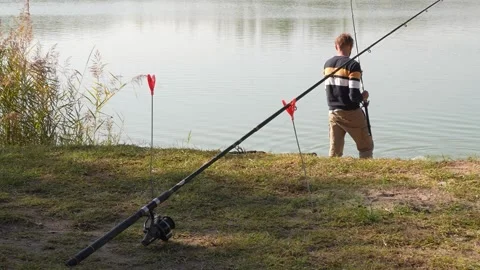 Angler fighting fish while the other rod is stationery Stock Footage 228673227