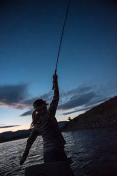 Angler hooked up as sun sets on river Foto stock