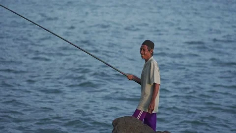 An angler smiles when he gets a fish in the sea Stock Footage 229600871