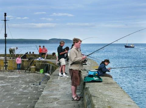Anglers sea fishing from a pier at Charlestown, Cornwall, UK. Stock Photos