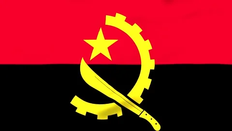 Angolan flag with yellow star and gear symbol on red and black Vídeos de archivo 343573611