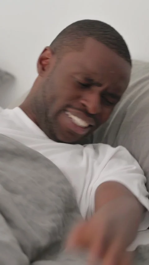 Angry African Man Lying in Bed Stock Footage 301855511