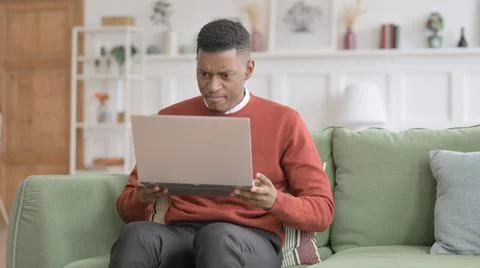 Angry African Man Using Laptop at Home Foto stock