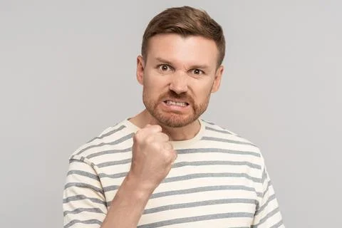 Angry aggressive middle aged man clenched fist has evil face looking at camera Stock-Fotos