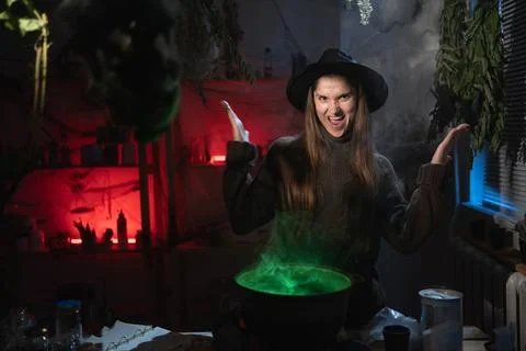 Angry Aggressive realistic witch brewing a potion in cauldron screaming suf.. Stock Photos