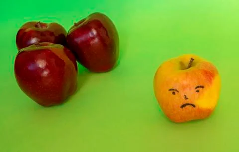 Angry apple face on green background. Stock Photos
