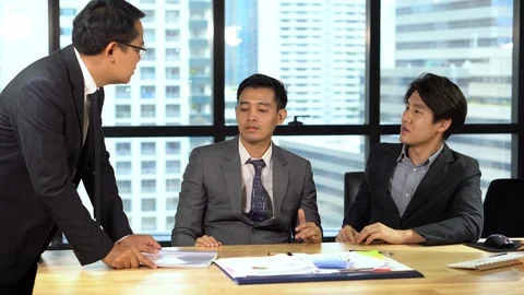 Angry boss hits the table with document paper on the table During assistant o Stock Footage 112729951