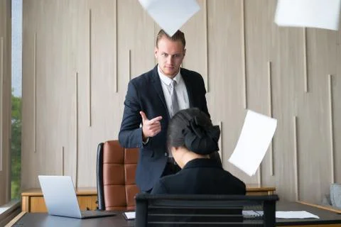 Angry boss serious throwing documents dissatisfied with bad work result emplo Stock Photos