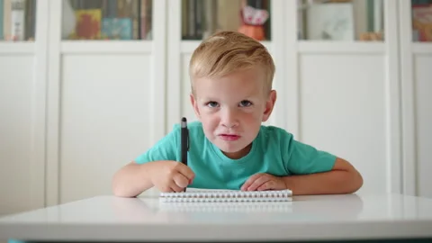 Angry boy doesnt want to study. Frowning kid in school. Angry little boy do.. Stock Footage 340727264